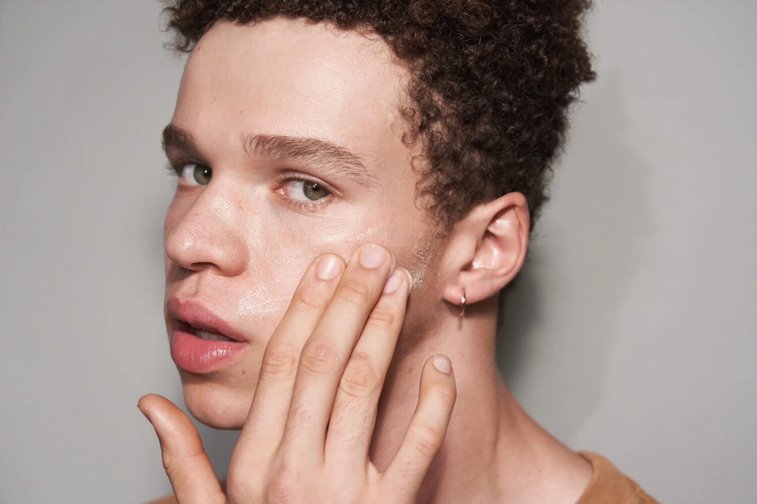 man applying product to face